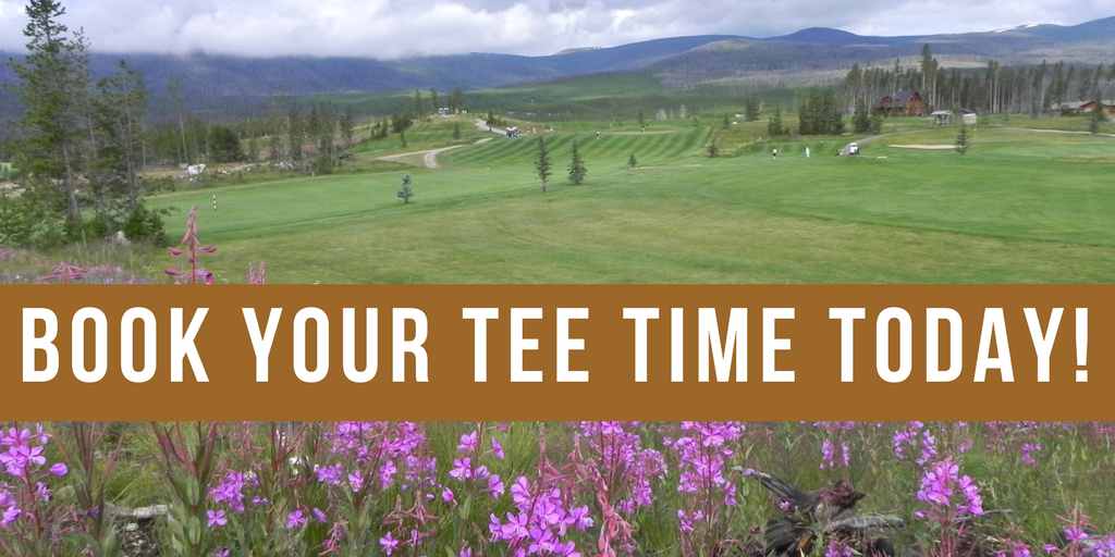 A golf course with purple flowers in the background.