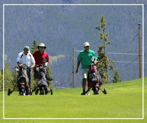 A group of people on a golf course with bags.