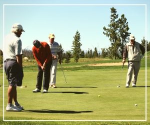 A group of people playing golf on the green.