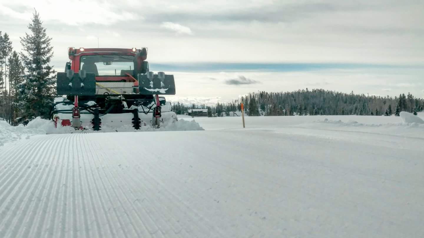 A truck driving down the road in the snow.